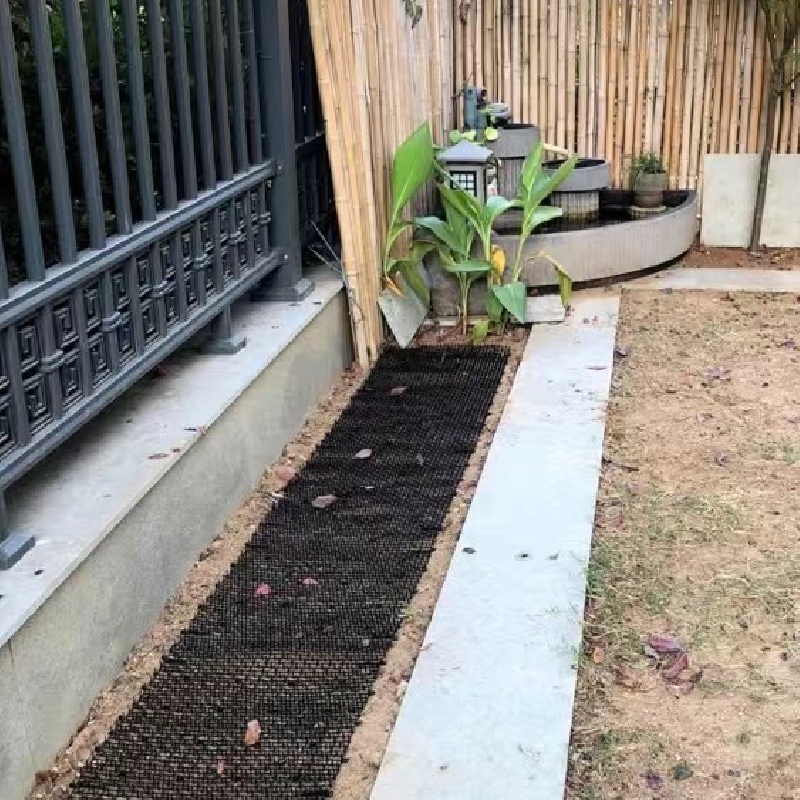 cat deterrent mat unrolls in the soil of garden